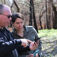 Clint McKay shows Allison Herrera some shots of the burn zone immediately after the fire sm